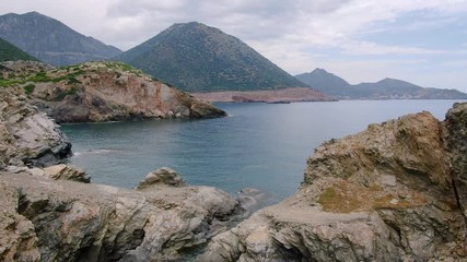 Aerial pull out over protected lagoon among rugged areas of the Greek Islands.