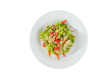 Caesar salad with pieces of chicken breast, tomato, bell pepper, cucumber, lettuce, walnuts on plate, white isolated background, view from above. For the menu, restaurant, bar, cafe