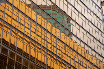 gold building with mirror reflection of another building