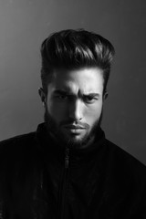 Close-up black and white portrait of a young handsome Caucasian male in studio. A man shows different human emotions.