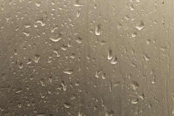 Raindrops flowing on a car body