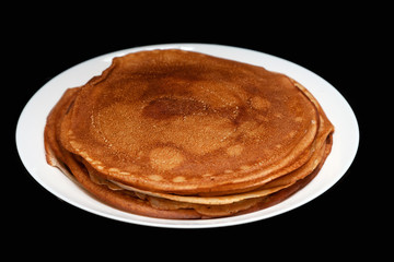 A stack of delicious hot and fresh thin pancakes baked in a pan of milk, flour and eggs for breakfast at home. Russian national holiday Shrovetide.