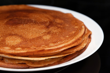 A stack of delicious hot and fresh thin pancakes baked in a pan of milk, flour and eggs for breakfast at home. Russian national holiday Shrovetide.