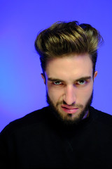 Obraz premium Beautiful caucasian young man portrait isolated on multicolored neon light backgroud. Young, smiling, surprised, screaming. Human emotions, facial expression concept. Trendy colors.Advertising concept