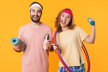 Portrait of young caucasian fitness couple holding sports equipments