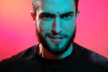 Beautiful caucasian young man portrait isolated on multicolored neon light backgroud. Young, smiling, surprised, screaming. Human emotions, facial expression concept. Trendy colors.Advertising concept