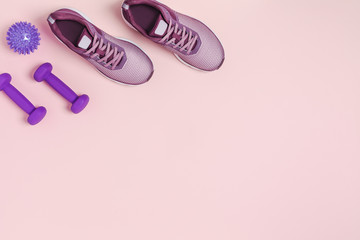 Sports equipment for women's training in pastel colored. Pink background.