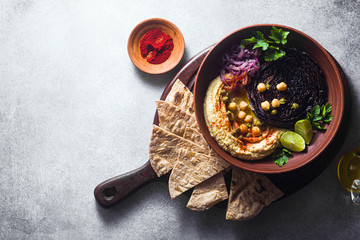 a bowl of hummus, baked purple cabbage and pickled red onion with a tortilla and smoked paprika