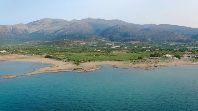 aerial view of the coastline and mountain on the island of Crete, Greece. City of Malia in the background.