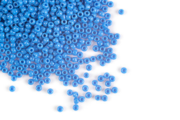 A scattering of blue glass beads on a white background