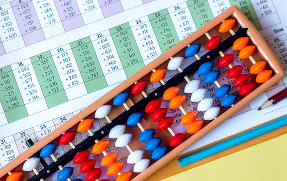 Mental arithmetic and development concept, abacus and mathematical examples on a yellow background