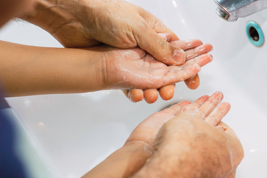  Dad Washing His Little Son's Hands With Soap And Water