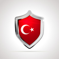 Turkey flag projected as a glossy shield on a white background