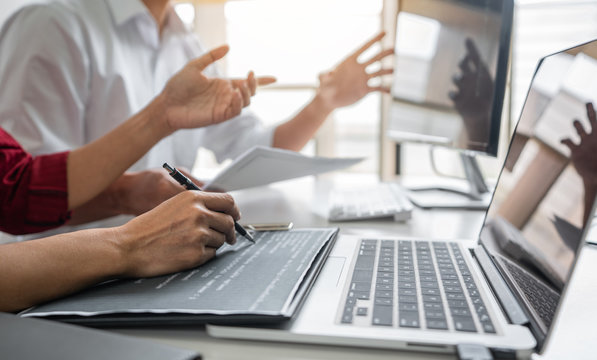 Two professional programmer cooperating and working on web site project in a software developing on desktop computer at company, codes and typing data code, Programming with HTML, PHP and javascript