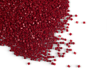 A scattering of red matte beads on a white background