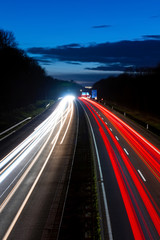 Fototapeta na wymiar Autobahn Deutschland Nacht Blaue Stunde Langzeitbelichtung Verkehr Licht Spuren Abend Hagen Hohenlimburg Kurve Abfahrt Auffahrt Kreuz Anschlusstelle Rush Hour Häuser Atmosphäre Mobilität Westfalen 