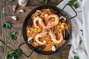 Top view, Seafood paella on wooden table with ingredients around