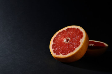 bright red sliced ​​grapefruit on a black background horizontal orientation
