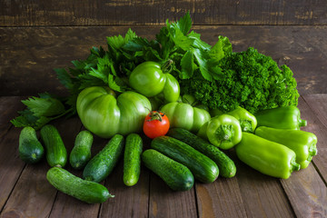 fresh organic green vegetables and red tomato on wooden table  peppers tomatoes cucumbers parsley lettuce