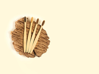 Bamboo toothbrushes on a wooden saw on a beige background. Ecostyle. Zero waste.