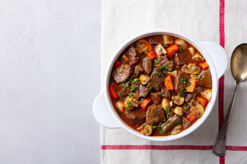 Beef bourguignon stew with vegetables. Grey background. Copy space. Top view. - obrazy, fototapety, plakaty