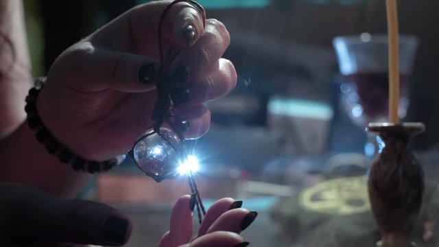 The sorceress holds in her hands a crystal ball. Conducts a spiritualistic session. Engaged in black magic, associated with the spirits and souls of the dead. Otherworldly forces, anamalous activity.