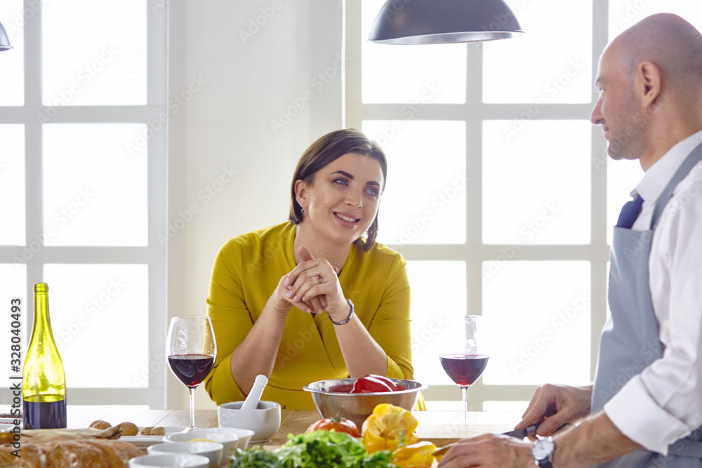 Wall mural Smiling young couple cooking food in the kitchen