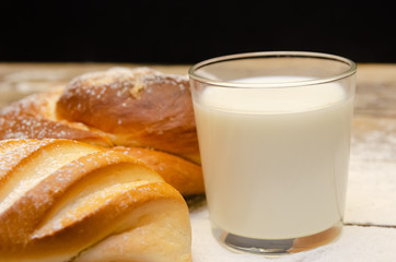 glass of milk, loaf, on a wooden background with flour. Balanced diet, protein and carbohydrates, cereals