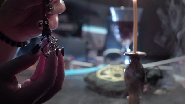 The sorceress holds in her hands a crystal ball. Conducts a spiritualistic session. Engaged in black magic, associated with the spirits and souls of the dead. Otherworldly forces, anamalous activity.