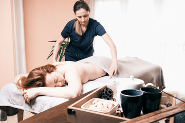 Obraz na płótnie Canvas massage therapists in the massage room massage the girl on the massage table