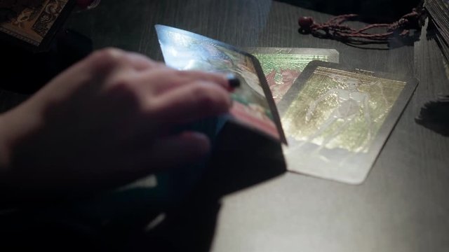 The witch lays out tarot cards. Conducts a spiritualistic session, looks at the future. Engaged in black magic, associated with the spirits and souls of dead. Otherworldly forces, anamalous activity