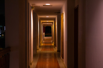 long straight corridor of a hotel hotel with dark lighting
