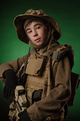 a boy in military uniform with a gun