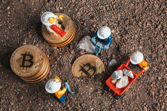 ANKARA, TURKEY. NOVEMBER 17, 2019. Lego mini miner figurines working with tools on ground to uncover bitcoins. Cryptocurrency, blockchain and mining concept.