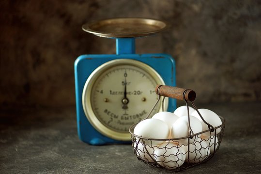 Chicken eggs in an iron basket on vintage soviet scales. - Powered by Adobe