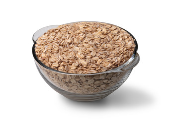 Oat flakes in a transparent glass bowl cut out on white background.
