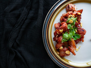 Fried Pork with Garlic Thai food Ingredients of pork ribs,Decorate the dish with red chilies, garlic and coriander on a white plate.