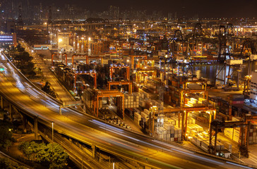Fototapeta na wymiar Container port illuminated Hong Kong harbour with gantry cranes