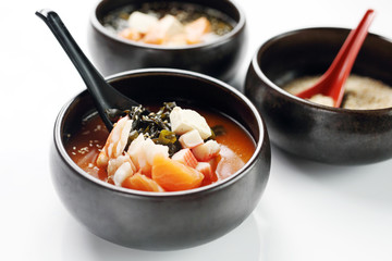 Misoshiru is a traditional Japanese soup with salmon and seafood. Traditional Japanese cuisine. Eastern cuisine. Dish on a white background