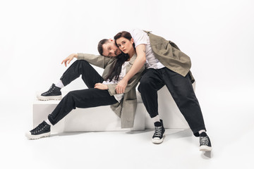 One whole. Trendy fashionable couple isolated on white studio background. Caucasian woman and man...