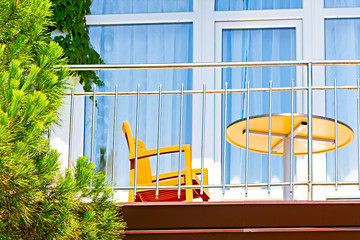 table and chair stand on an open balcony of a hotel in a southern country