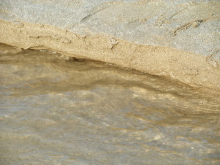 Fototapeta na wymiar Water flowing over sand forming pattern