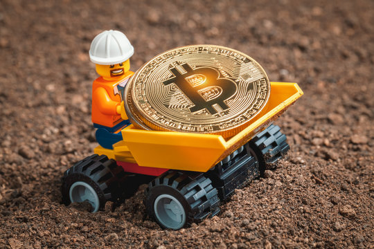 ANKARA, TURKEY. NOVEMBER 17, 2019. Lego mini miner figurine driving mining truck loaded with shiny bitcoins. Cryptocurrency, blockchain and mining concept.