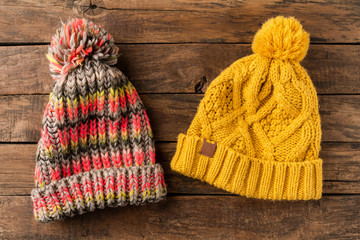 Colourful knitted hats on wooden background. Top view