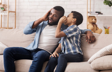 Black Son Sharing Secret With Dad, Whispering To His Ear