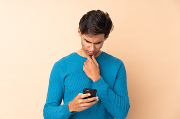Man over isolated background thinking and sending a message