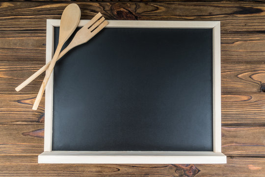 Frame for the menu. Chalk board and wooden spoon and fork. Restaurant cafe advertisement