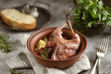 Rabbit stewed in wine with vegetables, rosemary and cherry.