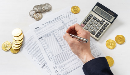 Taxation: a man in a jacket fills out a tax return on trading income on a cryptocurrency exchange.