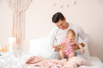 Obraz na płótnie Canvas Cute baby with father in bedroom